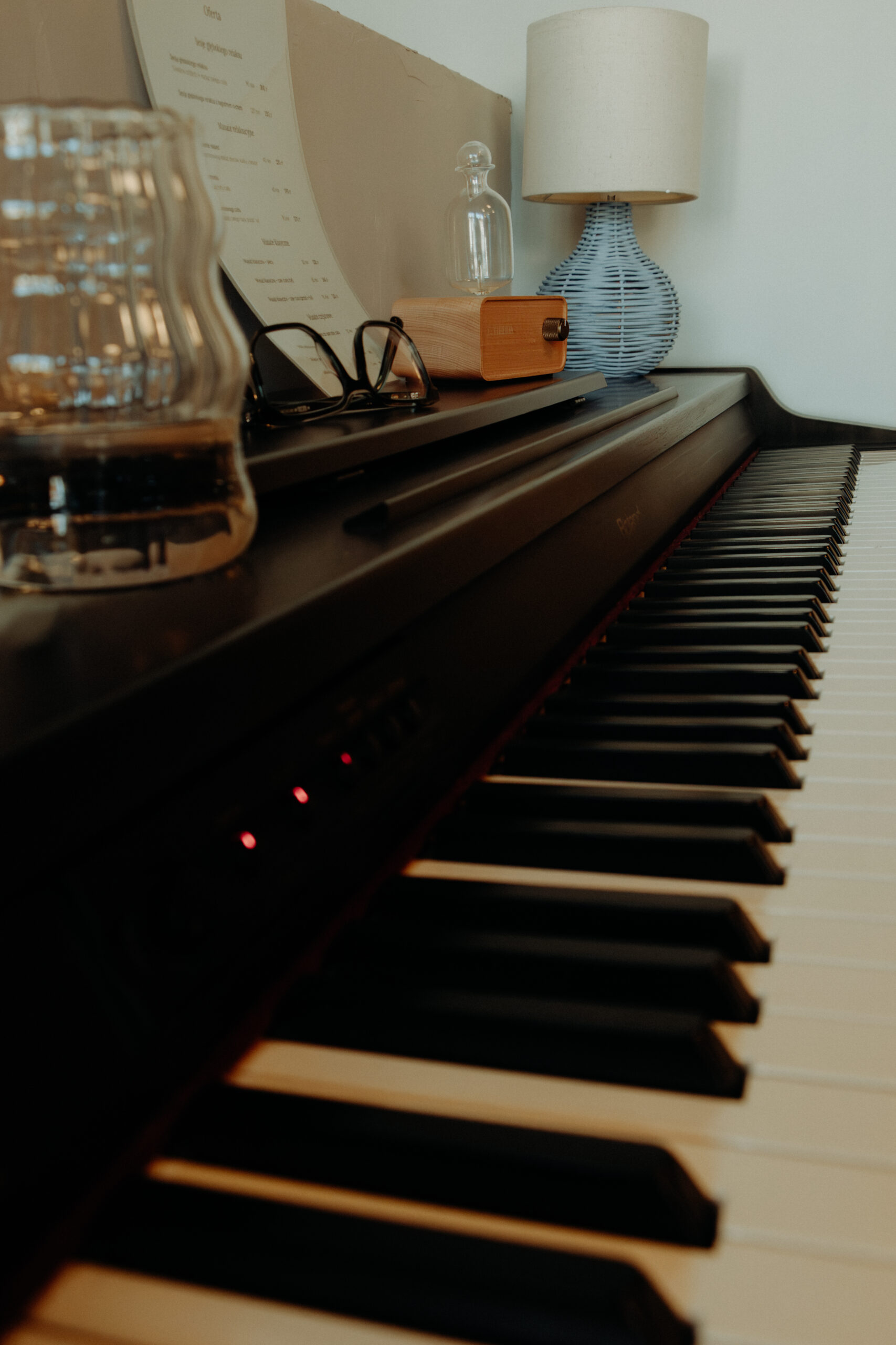 Piano with glasses and lamp on top